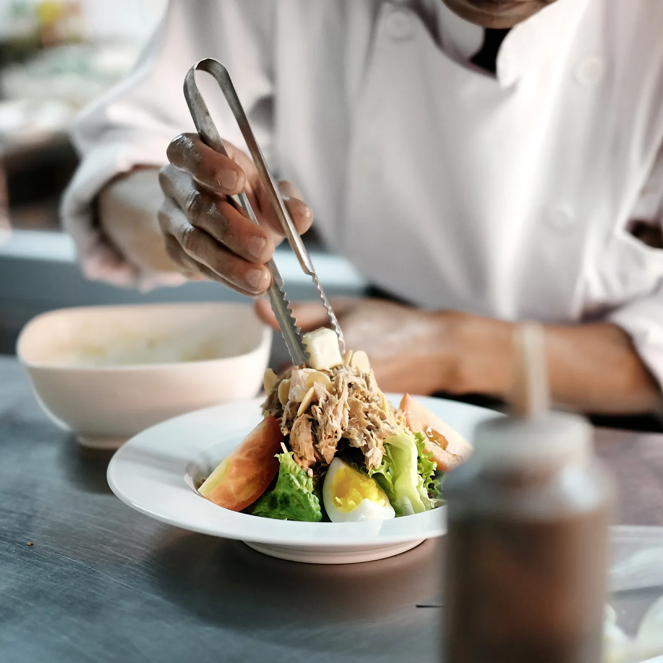 An OhLala chef carefully plating a dish